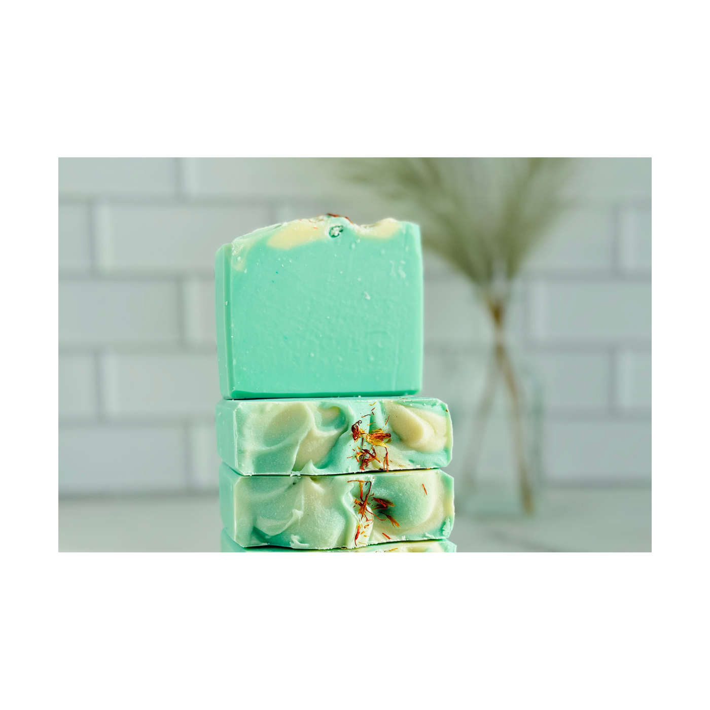 Handmade, natural yellow soap, two pieces one standing, one on a side, topped with colorful botanicals