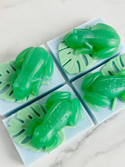 Green frog-shaped soaps on a white marble surface